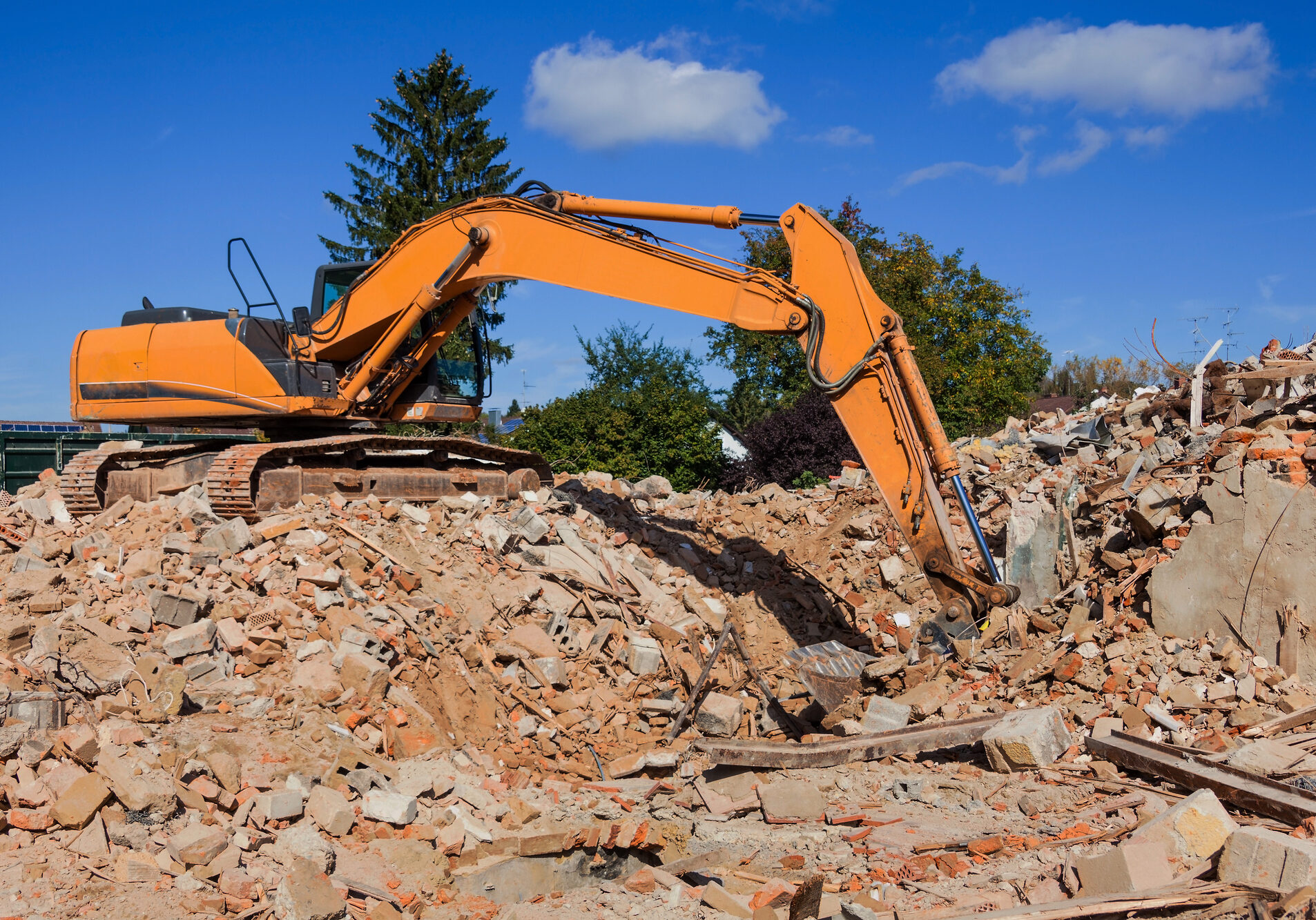 a building is demolished. excavator on the construction site. after demolition of new residential space will be created -